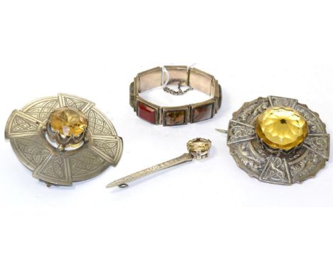Two large Scottish paste set plaid brooches, each with a round cut yellow paste claw set within a Celtic motif frame, a citri
