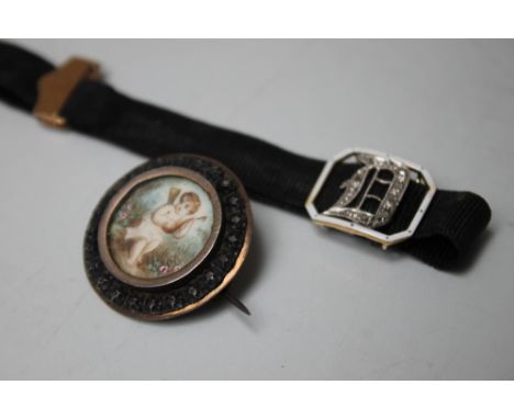 A LATE 19TH / EARLY 20TH CENTURY HAND PAINTED BROOCH, the central circular panel with painted image depicting a cherub playin