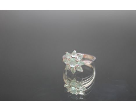 AN 18 CARAT WHITE GOLD GEM SET RING, in a floral style with light green stones, approx weight 4g, ring size N 1/2