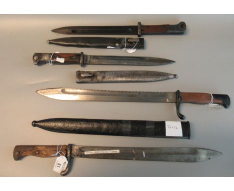 A group of four bayonets to include; two similar German First World War period bayonets and scabbards, a German 1898/05 secon