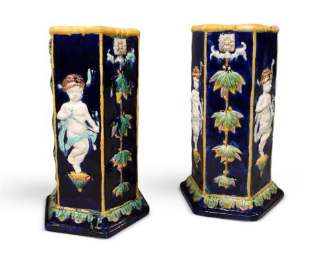 A PAIR OF MAJOLICA STICK STANDS LATE 19TH CENTURY Hexagonal bodies with decoration of Cupid and floral trailing stems 53.5cm 