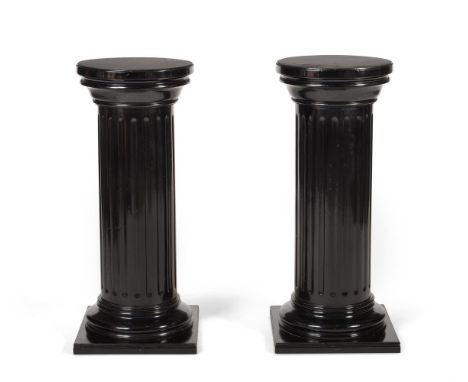 A PAIR OF EBONISED WOOD FLUTED COLUMNSLATE 19TH/EARLY 20TH CENTURY each 94cm high, the revolving tops 39cm diameter Condition