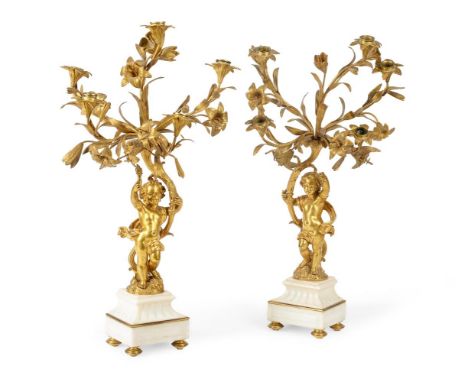 A PAIR OF FRENCH ORMOLU AND WHITE MARBLE FIVE-LIGHT CANDELABRA  19TH CENTURY  Floral candle branches on winged cherub support