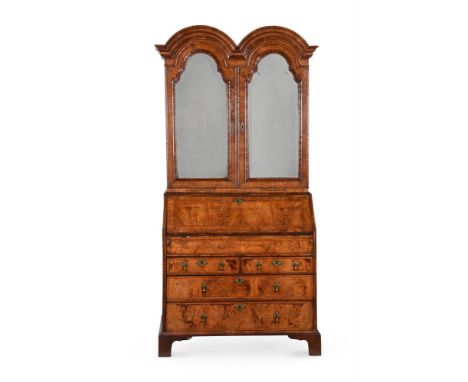 A QUEEN ANNE WALNUT DOUBLE-DOMED BUREAU CABINETEARLY 18TH CENTURY AND LATERThe mirrored doors enclosing drawers and recesses,