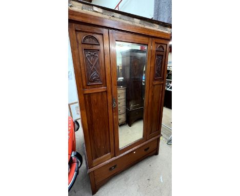 An Edwardian walnut single door wardrobe with a base drawer on bracket feet