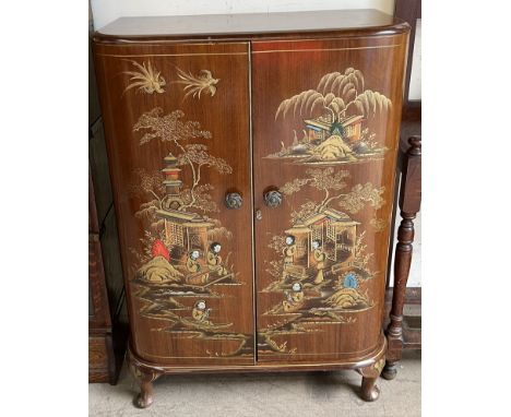 A Chinoiserie decorated drinks cabinet with hinged doors enclosing bottle compartments and shelves on cabriole legs 