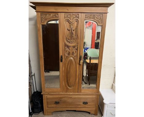 An Edwardian satin walnut wardrobe with a moulded cornice above a pair of mirrored doors and a drawer to the base on bracket 