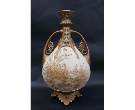A Royal Worcester twin handled vase with a reticulated flared top above a tear drop shaped body with raised decoration of a s