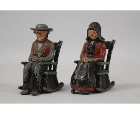A vintage set of cast metal, hand painted salt and pepper shakers in the form of an Amish couple sat in rocking chairs.