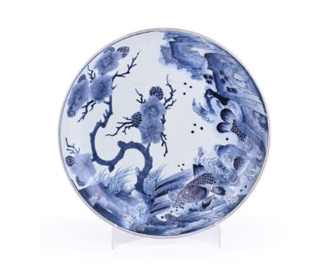 A large Japanese Arita porcelain dish, of typical circular, concave form resting on a short footrim, decorated in underglaze 