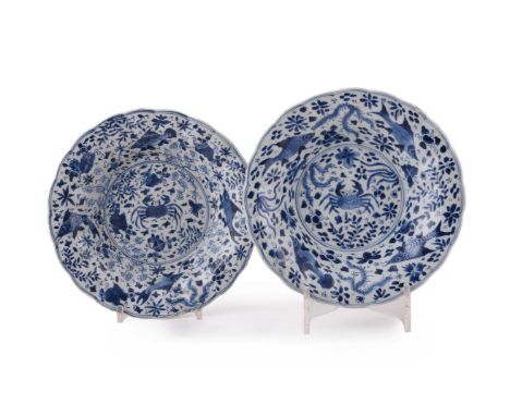Two Chinese blue and white 'crab and fish' dishes, Kangxi, on a dense ground of seaweed and various motifs, each with marks w