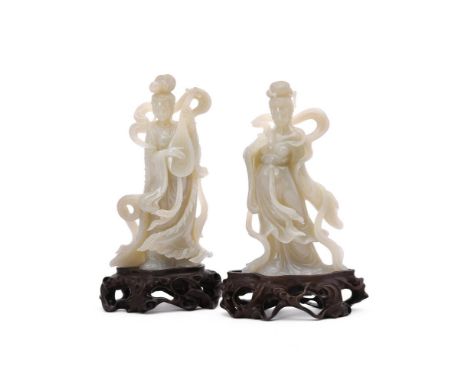 A pair of Chinese celadon jade carvings of ladies, circa 1950's, well carved with flowing robes and one with a musical instru