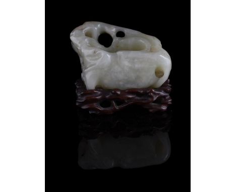 A Chinese celadon jade washer, Qing Dynasty, carved in the design of garden rockery, 7.5cm long x 4.5cm wide, with fitted har