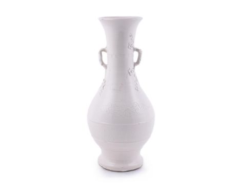 A Chinese blanc-de-chine porcelain vase, 18th century, applied to the neck with branch handles with prunus blossoms emanating