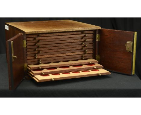 A coin cabinet  30 x 29 x 16.5cm, comprising 14 trays single-pierced to house a total of 444 coins, brass pulls, double doors