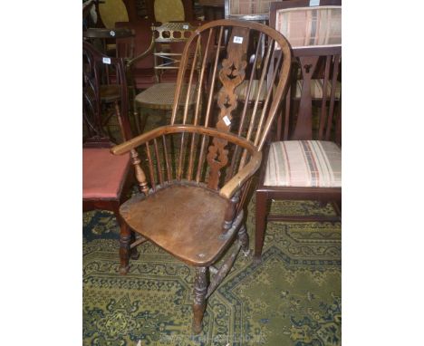 An appealing solid Elm seated kitchen Elbow Chair having fretworked central splat and stick back, turned legs, stretchers and