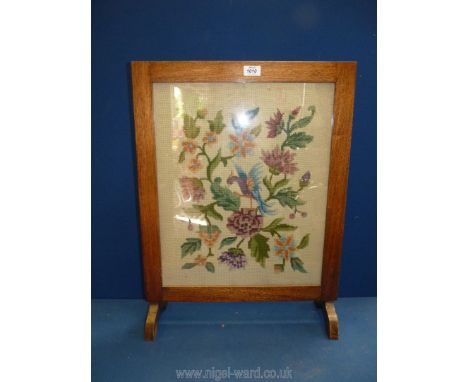 A tapestry Fire-screen depicting a colourful bird amongst similarly coloured flowers, 27'' high x 20'' wide