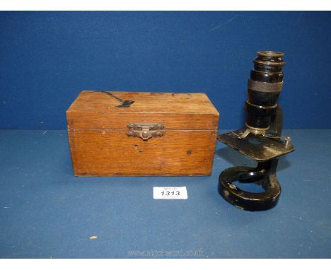 A small black microscope in wooden case.