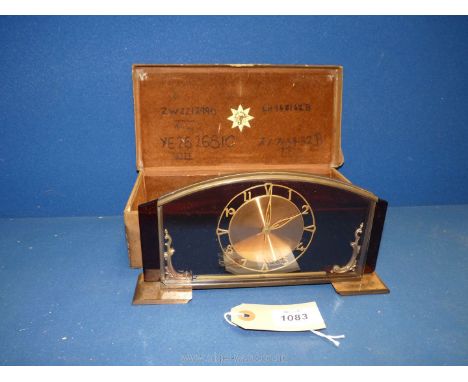 An unusual glass framed Junghans Clock in original case with copper coloured face. The case inscribed inside with four camp n