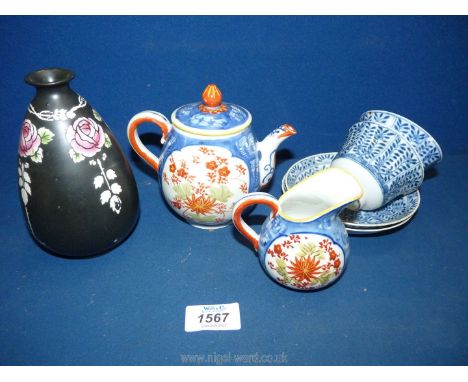 A vintage porcelain miniature teapot and a matching milk jug, and two small oriental blue and white tea bowls with two matchi