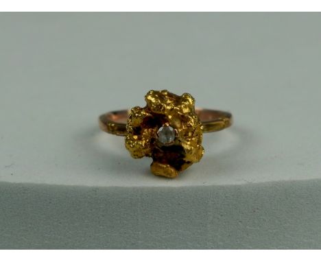 A 14CT GOLD RING SET WITH A LARGE GOLD NUGGET AND CLEAR STONE, Stone tests as not diamond. Weight: 5.0gms