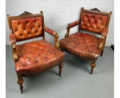A PAIR OF 19TH CENTURY BUTTON BACK FAUTEUILS, Each upholstered in red or tan leather, raised on four legs and castors. One ca
