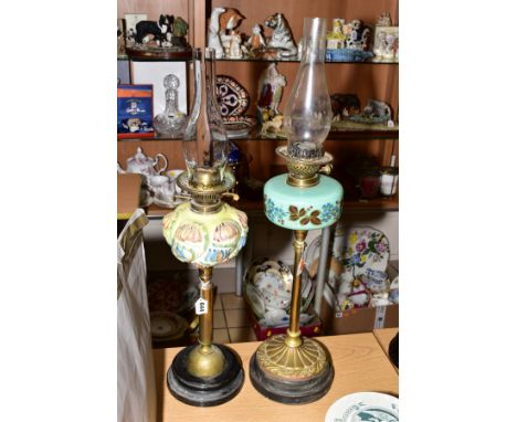 TWO TWIN BURNER OIL LAMPS, one having blown and hand painted glass reservoir, brass fittings, standing on a black ceramic bas