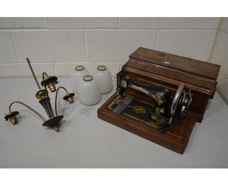 A MAHOGANY CASED SINGER SEWING MACHINE, together with a retro ebonised and brass triple branch ceiling light with shades (2)