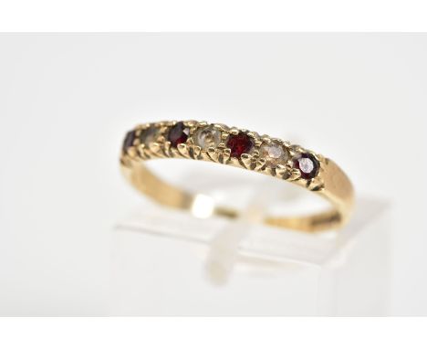 A 9CT GOLD HALF ETERNITY RING, set with four circular cut garnets interspaced with three circular cut white synthetic spinels