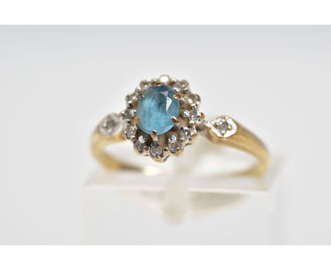 A 9CT GOLD CLUSTER RING, designed with a central oval cut blue topaz and single cut diamond surround and diamond detail shoul