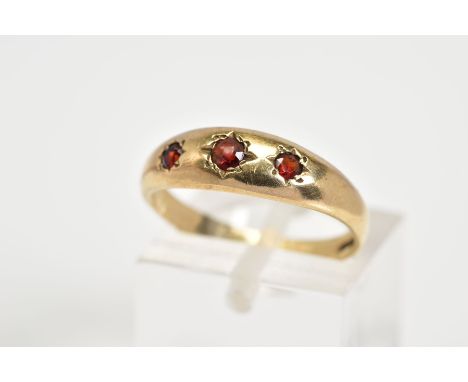 A 9CT GOLD THREE STONE RING, set with three graduated circular cut garnets within a plain polished band, with a 9ct hallmark 