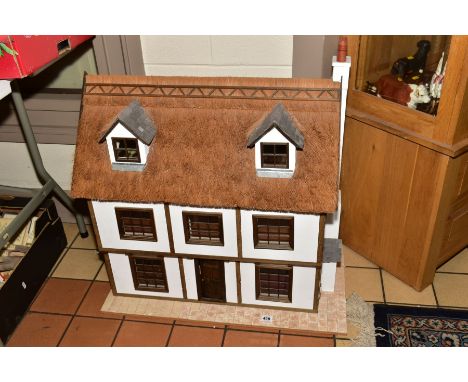 A WOODEN DOLLS HOUSE, modelled as a three storey thatched town house, front opens to reveal four rooms over two floors with c