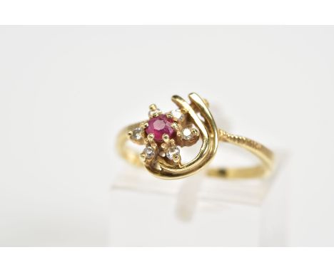 A 9CT GOLD CLUSTER RING, designed as a flower with a central circular cut ruby and brilliant cut diamond surround, with two c