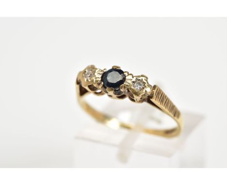 A 9CT GOLD THREE STONE RING, set with a central circular cut sapphire flanked by two single cut diamonds within an illusion s