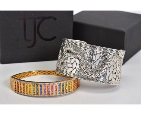 TWO BANGLES, the first a gold plated hinged bangle set with twenty two rows of princess cut tourmalines in a variety of colou