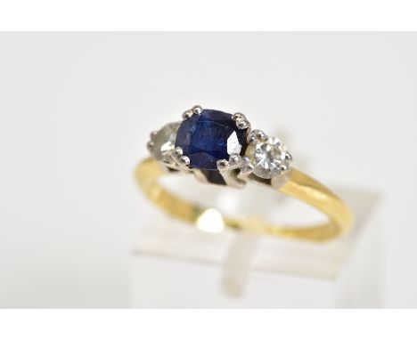 A THREE STONE RING, set with a central cushion cut sapphire flanked with two round brilliant cut diamonds within an open work