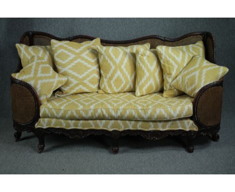 Bergere sofa, mid century mahogany framed in the French Provincial style, reupholstered and with double caning to the sides. 