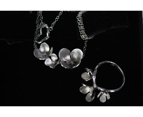 A boxed silver blossom design ring and matching necklace, sculptural in design. Both stamped 925. H.9 W.8cm. (box) 