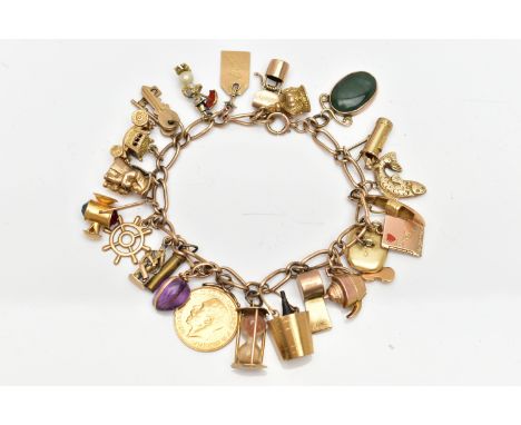 A 9CT GOLD CHARM BRACELET SUSPENDING TWENTY FOUR CHARMS, the fancy link chain with lobster clasp, partial hallmarks for 9ct g