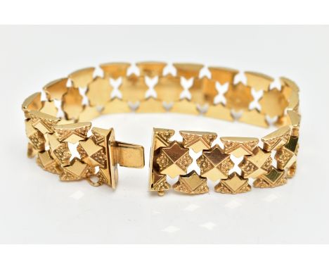 A YELLOW METAL FANCY LINK BRACELET, a wide bracelet made up of star shape links with floral detailing, approximate width 16.5