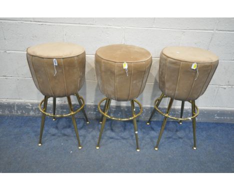 A SET OF THREE LIGHT BROWN UPHOLSTERED STOOLS, on four cylindrical brassed legs, with a foot rest, height 74cm (3)
