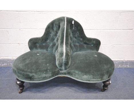 A VICTORIAN TWO SEAT CONVERSATION SOFA, with a buttoned back and covered in green fabric, on turned legs and ceramic casters,