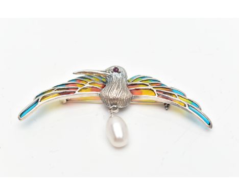 A WHITE METAL PLIQUE A JOUR HUMMINGBIRD BROOCH, the textured hummingbird, with circular cut ruby eye detail, enamelled wings,