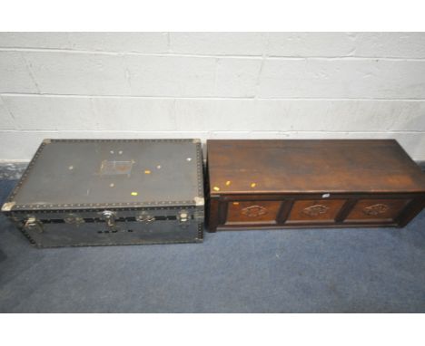 A 2OTH CENTURY OAK PANNELED BLANKET BOX, a length 123cm x depth 45cm x height 35cm, along with a metal travelling trunk (cond