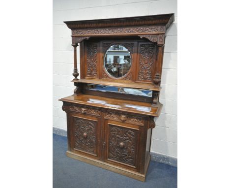 A LATE VICTORIAN CARVED OAK MIRROR BACK SIDEBOARD, the top with a circular bevelled mirror central too two reeded uprights, o