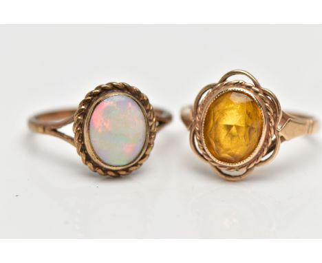 TWO YELLOW METAL RINGS, to include a 9ct gold opal single stone ring set with an oval opal cabochon within a rope twist surro