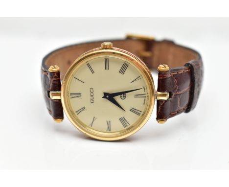 A GOLD PLATED 'GUCCI' WRISTWATCH, quartz movement, round cream dial signed 'Gucci', Roman numerals, polished plated case with