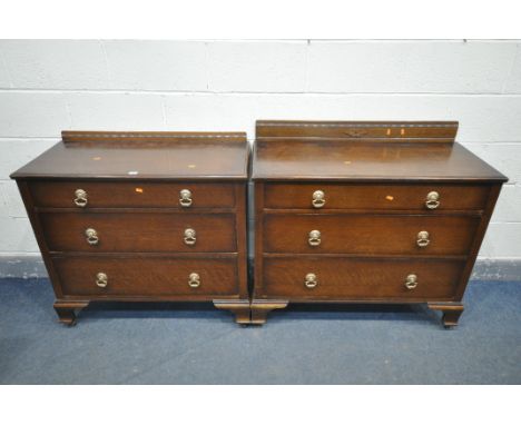 A NEAR PAIR OF OAK THREE DRAWER CHEST OF DRAWERS, one with a higher raised back, on bracket feet, and casters, largest chest 