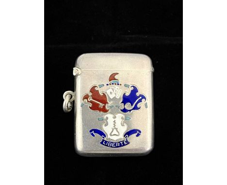 An Edwardian silver and enamel vesta case, of rounded rectangular form, the front enamelled with a faux coat of arms incorpor