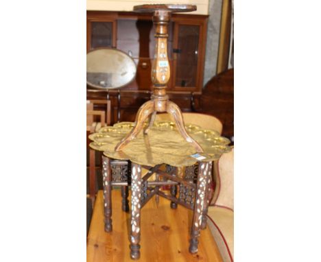 		An eastern folding table with brass top, inlaid with mother-of-pearl together with a small tripod table similary decorated